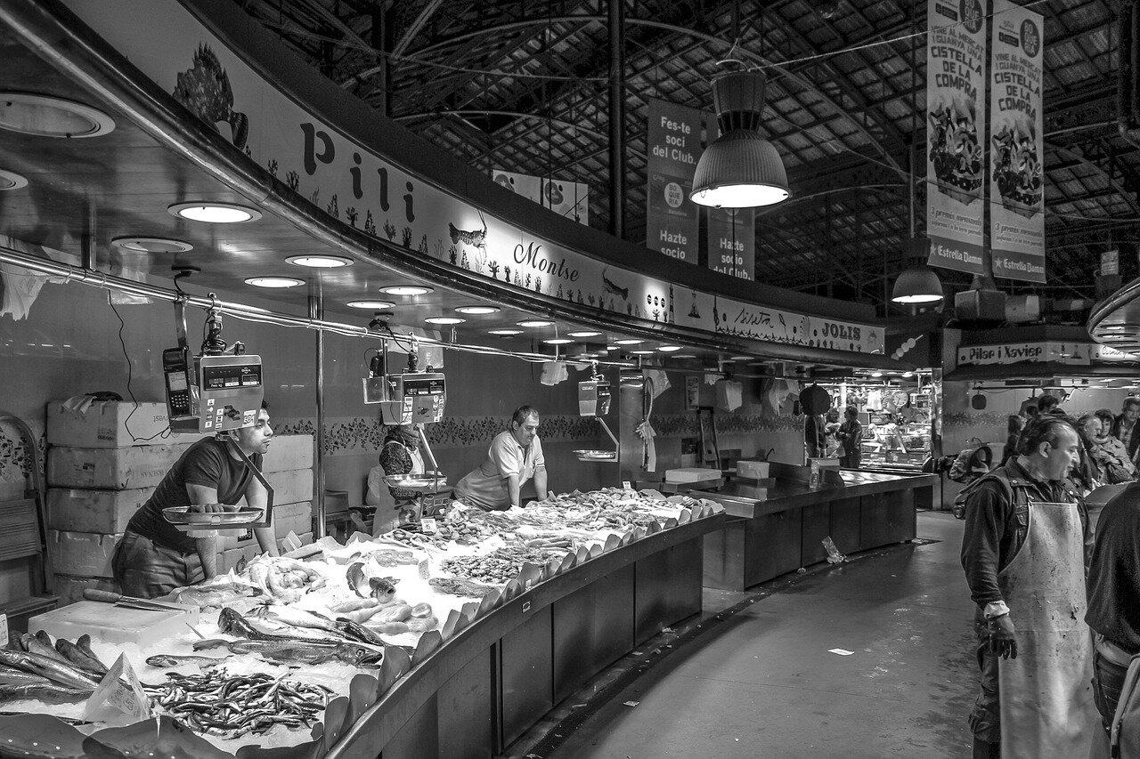 Fishmongers working behind a seafood counter in a Catalan market